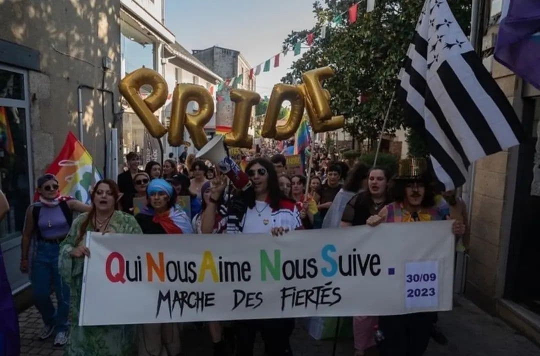 photo du cortège pendant la première pride de Clisson tenant la bannière de l'association Qui Nous Aime Nous Suive.